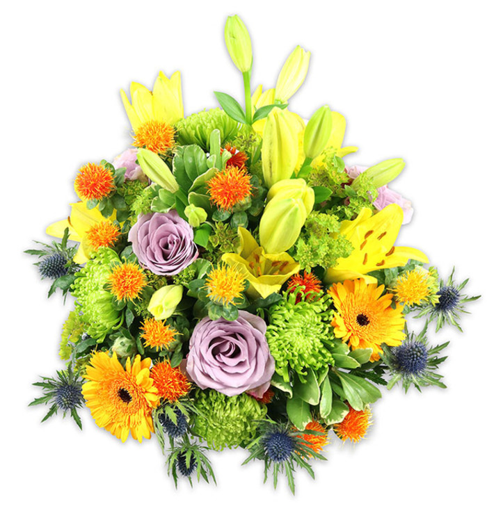 A densely packed, vibrant floral composition set against a pristine white background, this bouquet balances bold warmth with unexpected cool accents to great effect. Several yellow Asiatic lilies provide upward movement-some fully open and freckled, others held as tapered greenish-yellow buds-while soft lavender-purple roses act as a calm focal point, their layered petals unfolding like a gentle spiral. Bright orange Gerbera daisies with their broad, flat petals punctuate the arrangement, and abundant lime-green 'button' chrysanthemums create plush, textured mounds that give the bouquet its generous fullness. Interspersed among these are small, globe-shaped orange and golden-yellow blooms-craspedia-like accents-that introduce playful, spherical highlights, and a handful of blue-grey sea thistles (Eryngium) push through the lower edges, offering a cool, spiky architecture that contrasts beautifully with the warmer flowers. Varied foliage-long, glossy lily leaves and smaller rounded greens-frames and unifies the composition, while soft lighting reveals the tactile differences between satiny rose petals, papery lily tepals, and the coarse thistle bracts. The overall effect is celebratory yet refined, suitable as a vibrant centrepiece for a dining table in Colney Hatch, a thoughtful congratulations arrangement for a neighbour on Colney Hatch Lane, or a bright, comforting bouquet to mark anniversaries and get-well wishes. The piece reads as both modern and timeless, reflecting the hand of a practiced florist who has considered colour, scent, form, and local tastes in every stem chosen.
